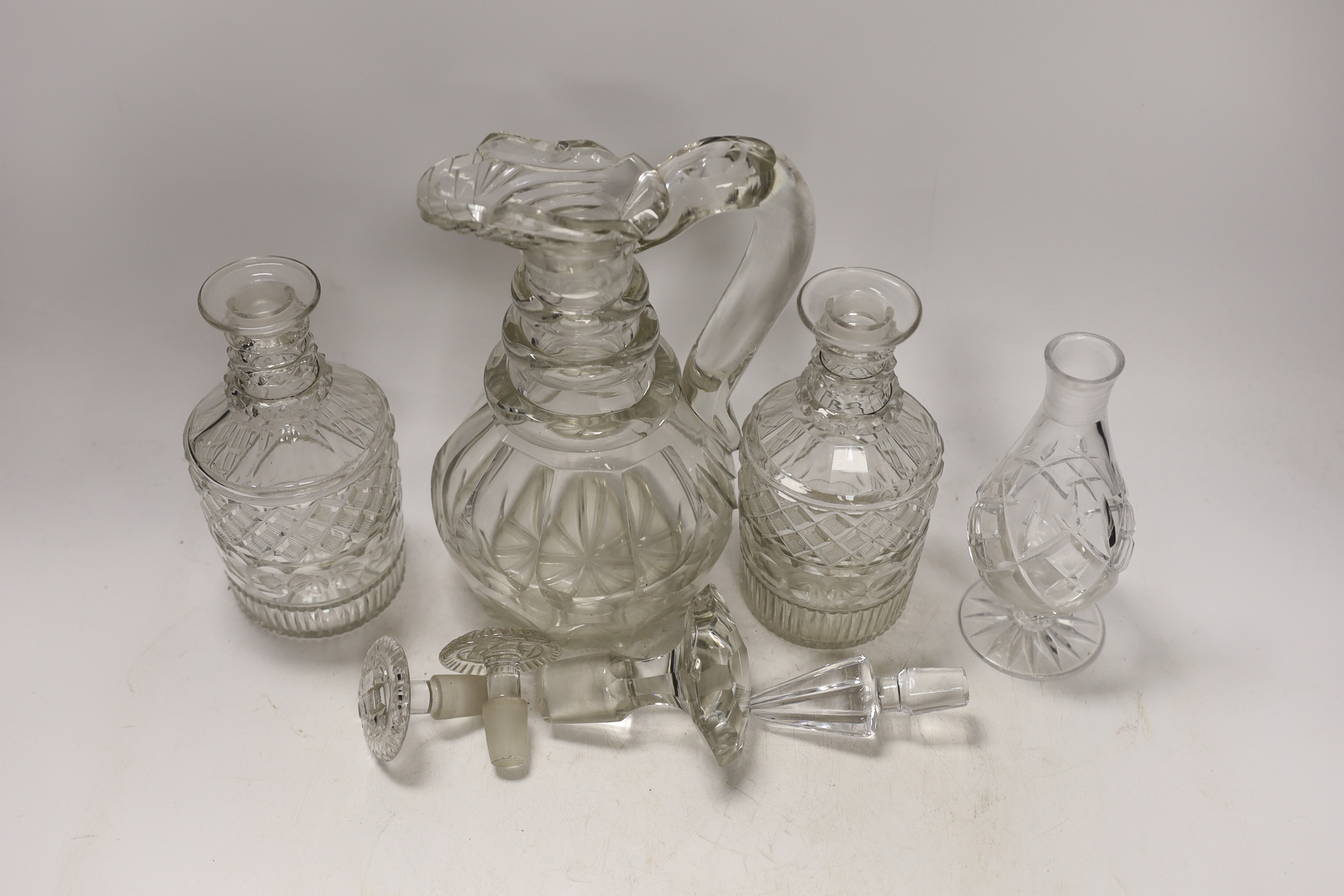 An early 19th century glass ewer, a pair of decanters and a jar, tallest 25cm